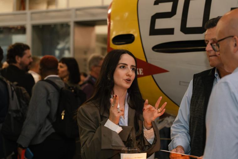 Busy from start to finish An attendee talks with two revenue leaders beside a vintage aircraft at GTM2026